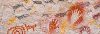 cave walls with drawings of handprints and animals