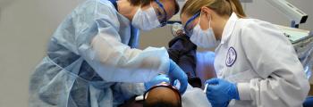 dental hygenists in protective gear with a patient