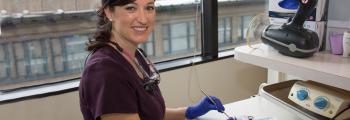 female dental hygenist in purple scrubs