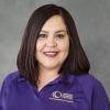 Smiling woman with dark brown shoulder-length hair wearing purple shirt