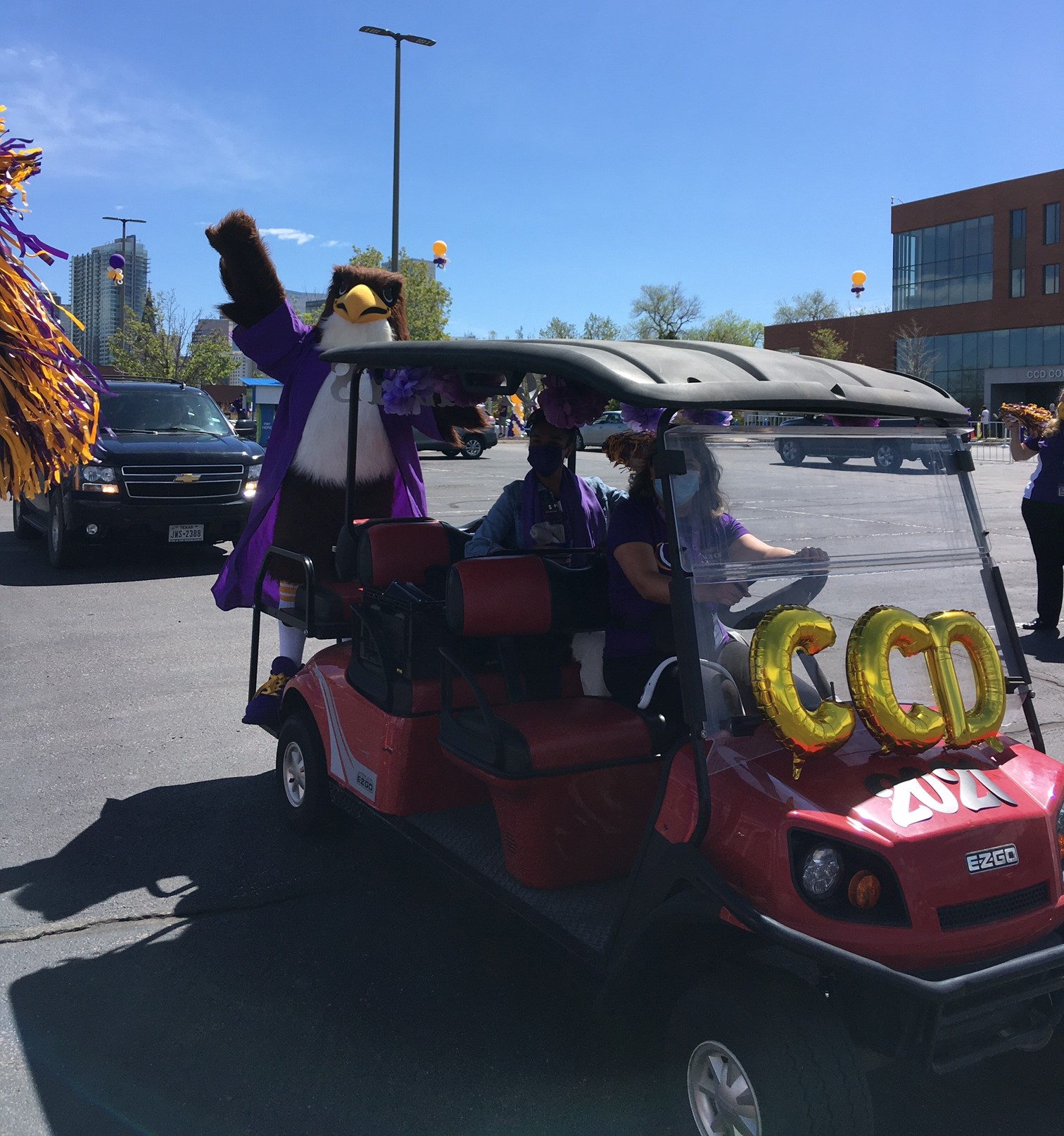CCD mascot, Swoop, riding on a decorated golf cart at graduation