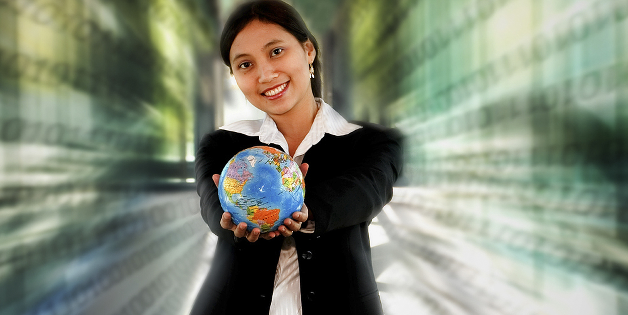 Woman wearing a suit holding a globe in outstretched hands Woman wearing a suit holding a globe in outstretched hands